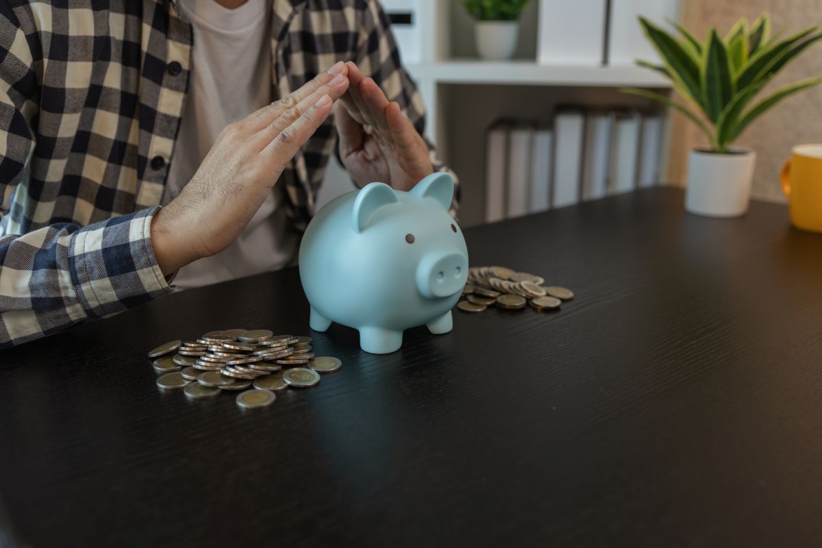 Un homme met une pièce dans une tirelire