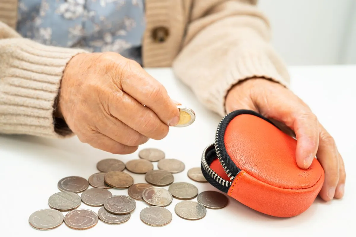 Une vieille dame compte ses pièces de monnaie
