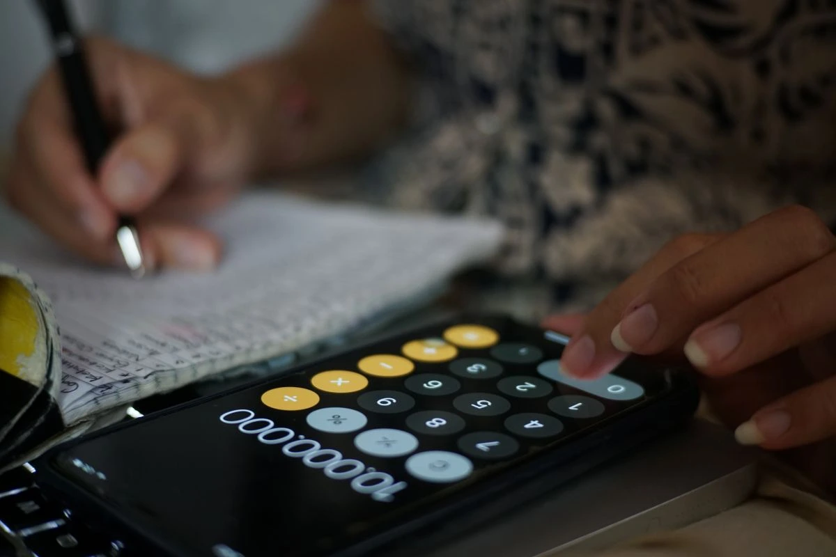 Une femme fait un calcul avec son portable