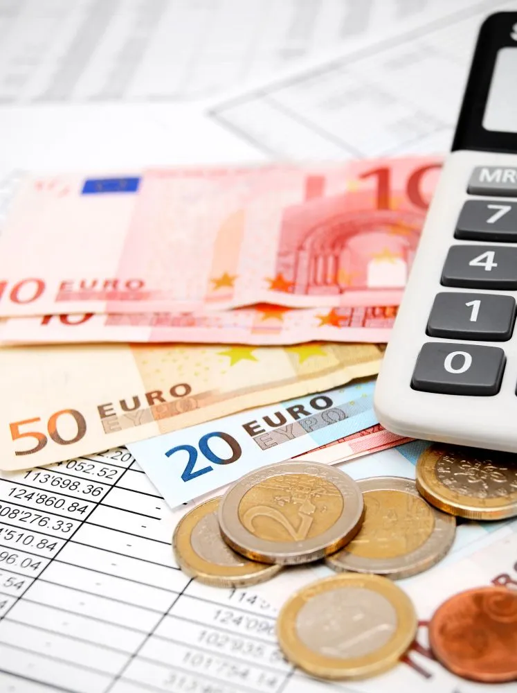 Une calculatrice entourée de billets