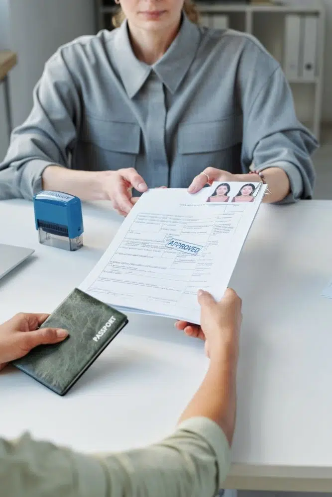 Une femme remet un passeport et des documents à un homme