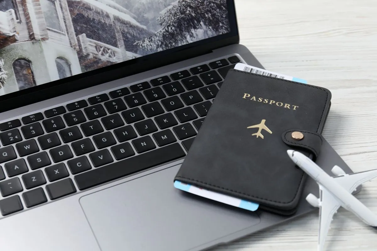 Un passeport et une figurine d'avion posés sur un ordinateur
