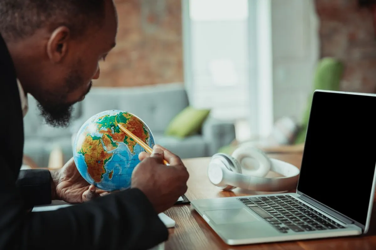 Un homme regarde un globe terrestre
