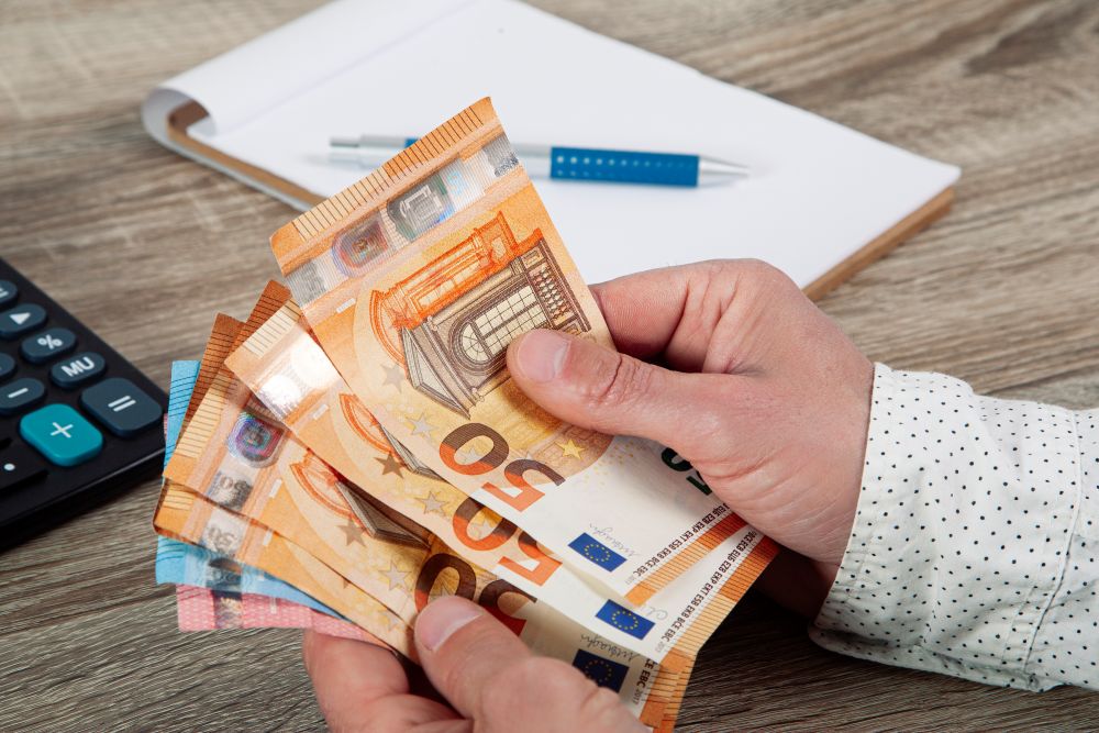 Une main d'homme compte des billets de banques