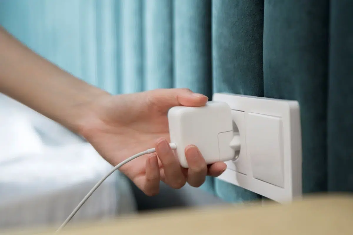 Une main débranche l'alimentation d'un ordinateur