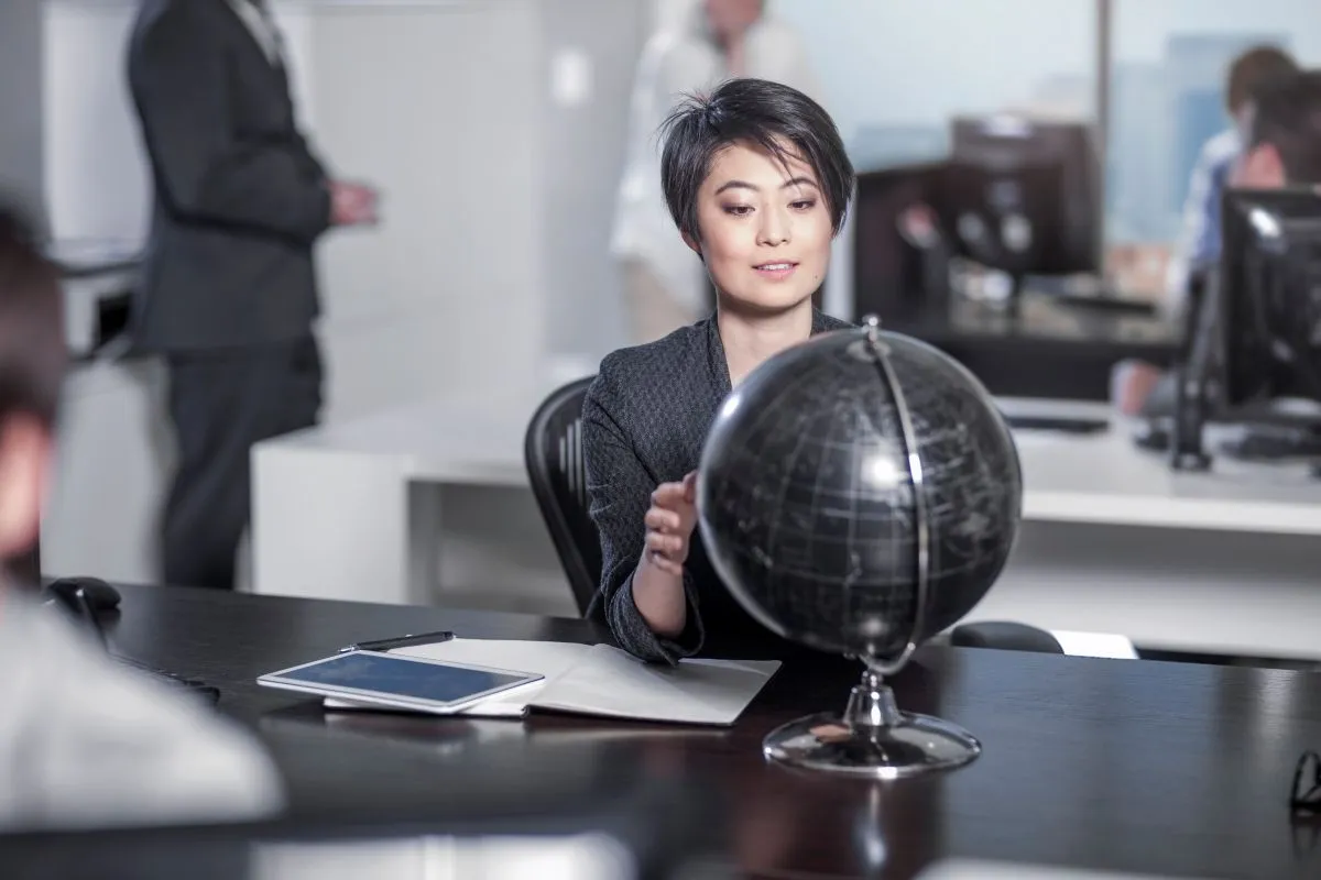 Femme regardant le globe, assise au bureau de la ville
