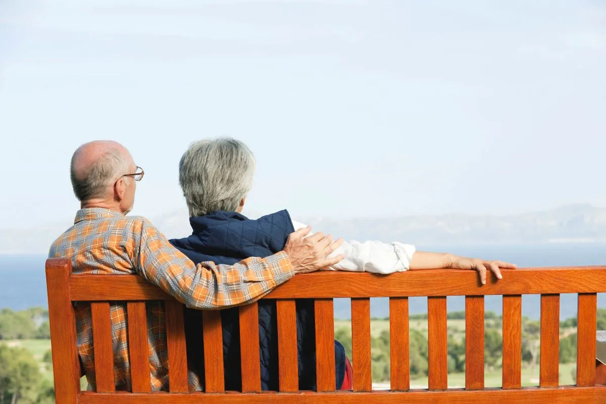 couple de personnes âgées assis sur un banc,