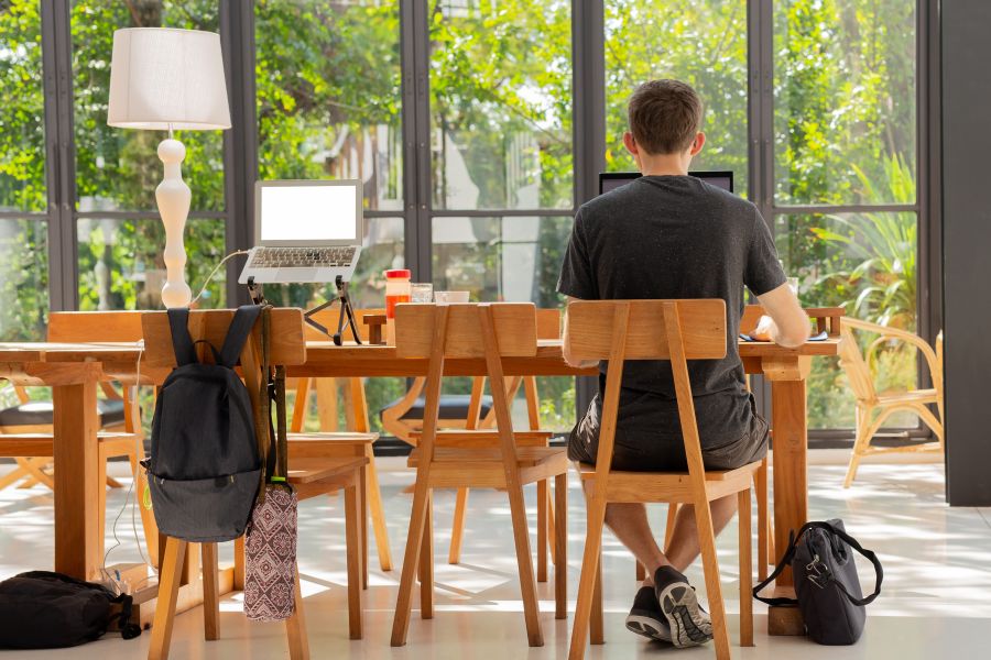 Un freelance assis au café travaillant sur un ordinateur portable.