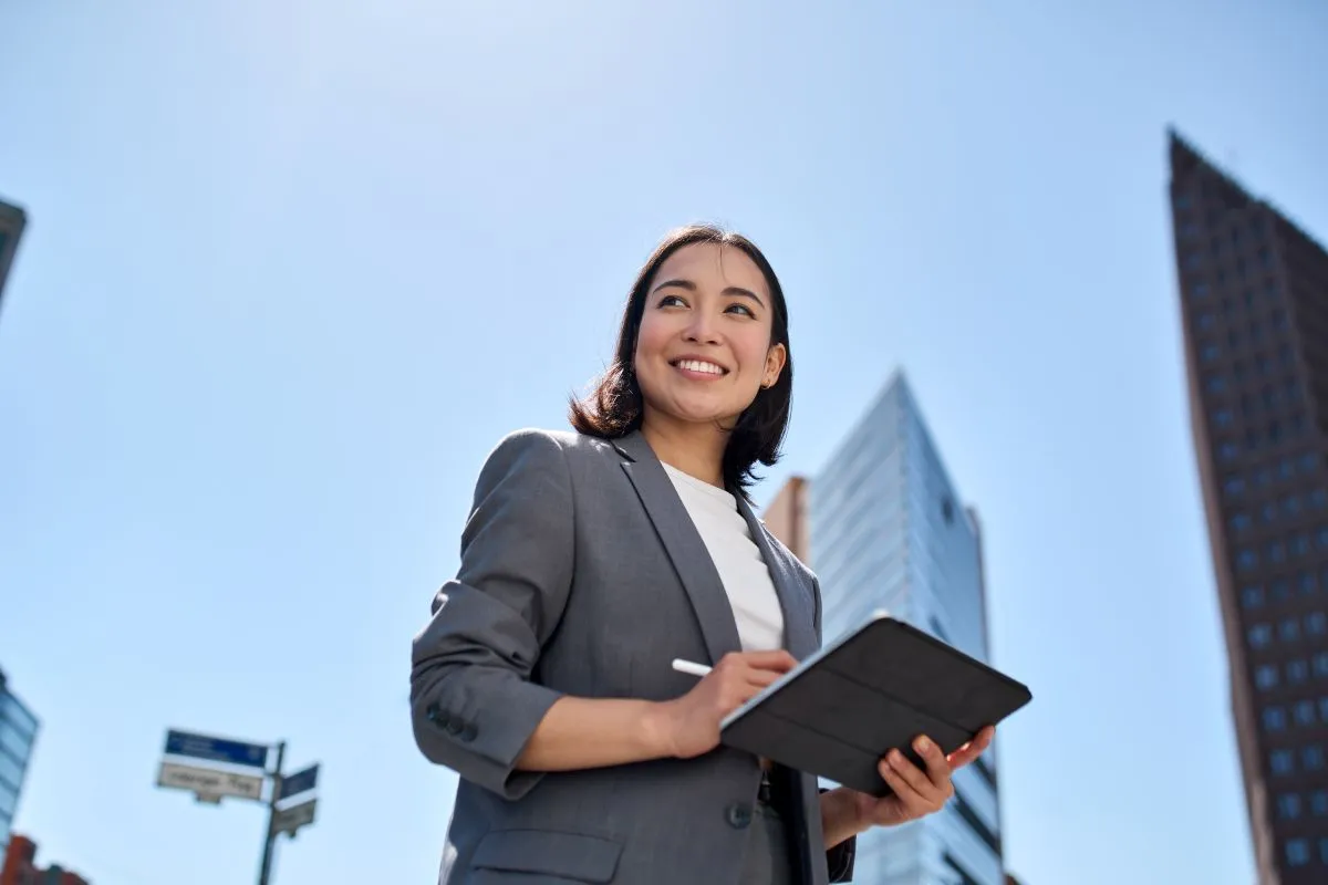 Une femme d'affaires souriante au milieu des immeubles